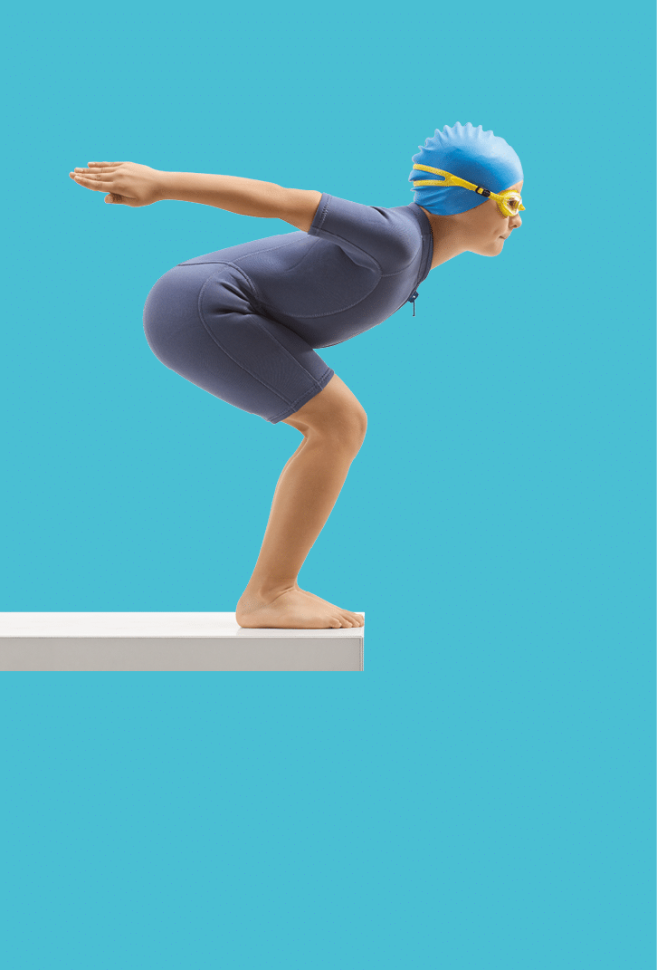 Full length profile shot of a boy in a wetsuit getting ready to jump for a swim isolated on white background