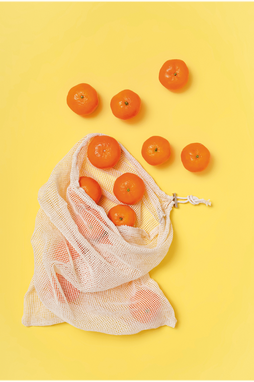 Using a reusable bag to buy food, instead of using plastic bags. Yellow copy space.